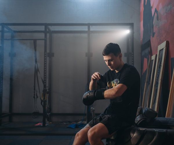 Silhouette of a man stretching against a sunrise, symbolizing renewal and energy.